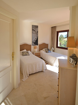 The twin bedroom at Menara Beach has an ensuite shower room and a private terrace